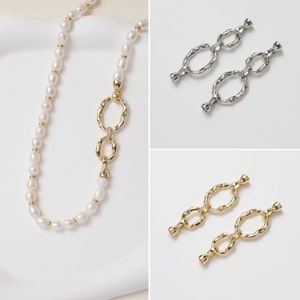 Puede incluir: Un collar de perlas con una cadena de oro que presenta dos abalorios ovalados unidos. El collar está sobre una superficie blanca. También se muestran dos juegos de eslabones de cadena de oro y plata sobre superficies blancas.