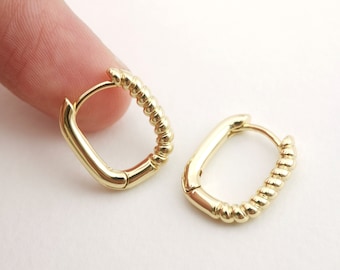 May include: A pair of gold hoop earrings with a twisted design. The earrings are small and delicate.
