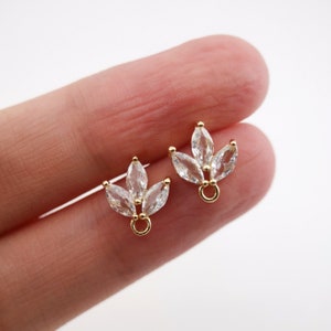 Op de afbeelding: Een paar gouden oorbelsluitingen met een cluster van heldere marquise-vormige kristallen.