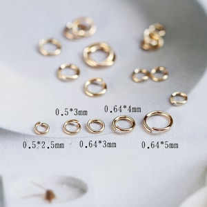 May include: Assortment of gold jump rings in various sizes. The jump rings are arranged in rows with their measurements labeled in millimeters.  0.5*3mm, 0.64*4mm, 0.5*2.5mm, 0.64*3mm, 0.64*5mm.