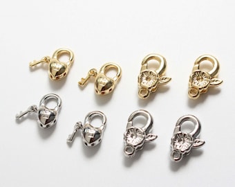 May include: Six gold and silver tone metal clasps with keyhole and flower designs. The clasps are for jewelry making.