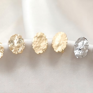 May include: Six pairs of earrings in gold and silver. The earrings are round and have a hammered texture.