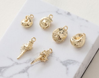 May include: Six gold-colored seashell charms with a loop for attaching to jewelry or other crafts.