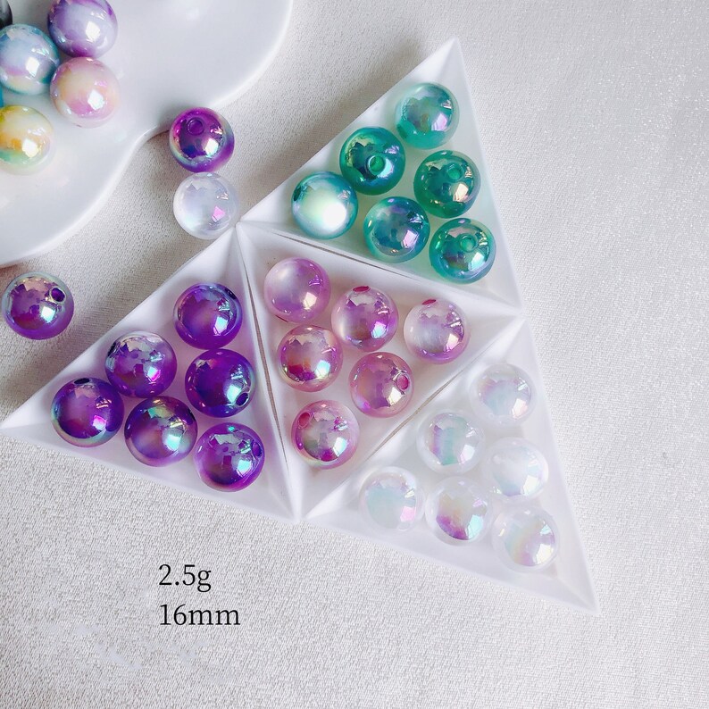 May include: Assortment of iridescent glass beads in various colors, including purple, pink, green, and white. The beads are 16mm in diameter and weigh 2.5g each.