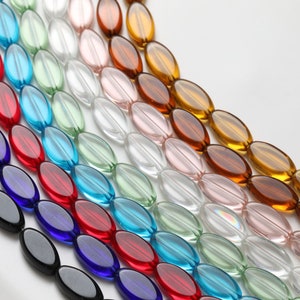 May include: Rows of oval-shaped beads in various colors, including red, blue, green, and amber. The beads are translucent and appear to be made of glass or a similar material. The beads are arranged in diagonal lines.