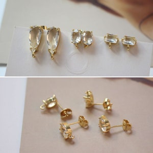 Puede incluir: Surtido de hallazgos de pendientes de tono dorado con piedras de cristal transparentes. Los hallazgos incluyen formas de lágrima, ovaladas y rectangulares.