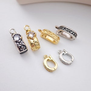 Puede incluir: Cinco estilos diferentes de cierres de metal dorado y plateado para collares o pulseras. Los cierres presentan diseños ornamentados y algunos tienen diamantes de imitación transparentes.