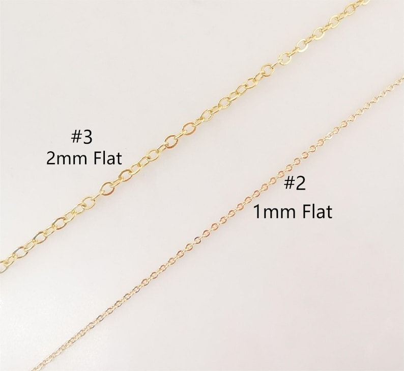 Puede incluir: Dos cadenas de oro, una cadena plana de 2 mm etiquetada como #3 y una cadena plana de 1 mm etiquetada como #2.