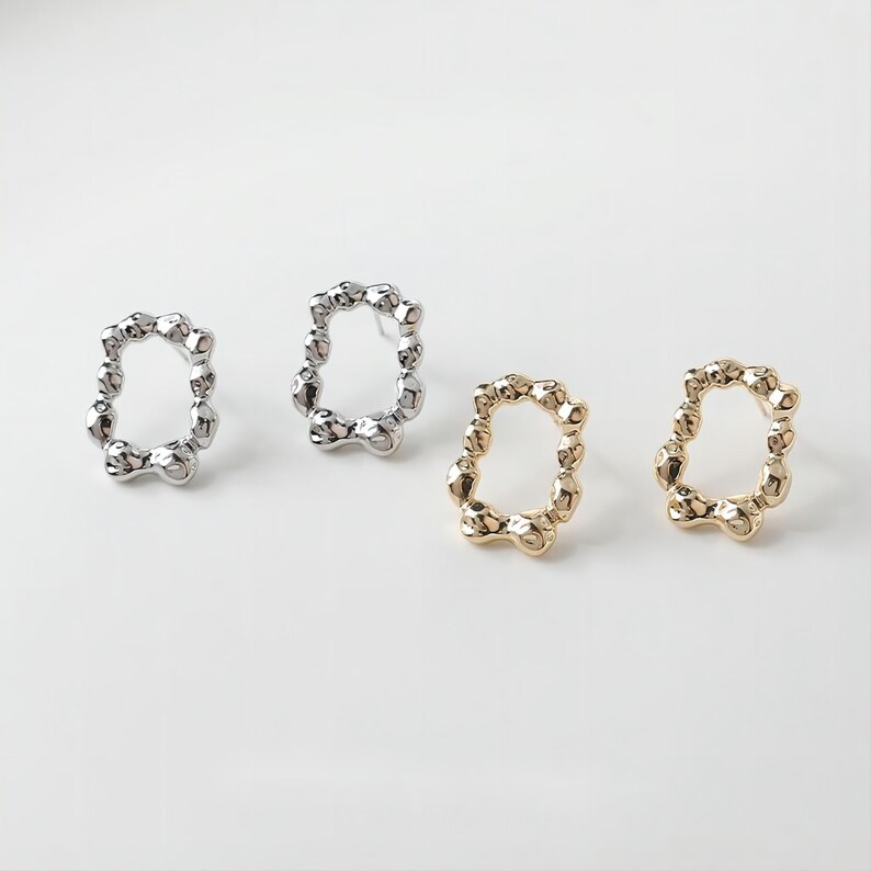 May include: Two pairs of earrings, one pair is silver and the other is gold. Both pairs are made of small, round beads that are connected to form a circle.