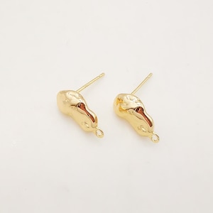 Puede incluir: Un par de hallazgos de pendientes de tono dorado con una forma irregular texturizada y un anillo de salto. Los hallazgos están diseñados para ser utilizados con otros componentes de joyería.