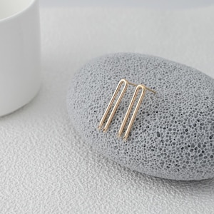 May include: A white ceramic mug with a black handle and the text "But First, Coffee" in a black, handwritten-style font. The mug is on a white surface.