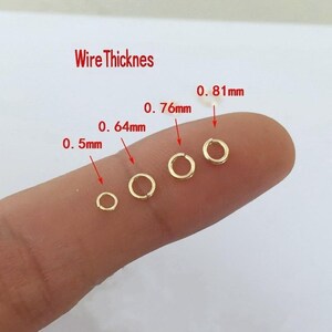 May include: Five gold jump rings of different sizes, labeled with their wire thickness in millimeters: 0.5mm, 0.64mm, 0.76mm, 0.81mm.  Wire Thickness is the text at the top of the image.
