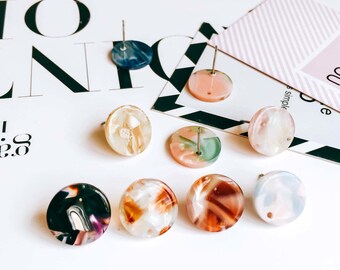 May include: Assortment of eight colorful round stud earrings with a marbled pattern. The earrings are made of resin and have a silver post.