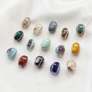 May include: Assortment of 15 ceramic oval beads in various colours and patterns. The beads have a glazed finish and are perfect for jewellery making.