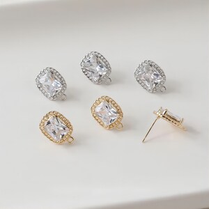 Peut inclure: Cinq paires de fermoirs de boucles d'oreilles avec une pierre carrée transparente sertie dans un cadre doré ou argenté. Les fermoirs ont une boucle pour attacher une boucle d'oreille pendante.