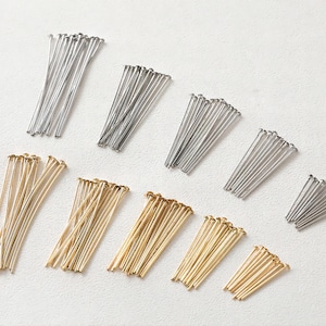 Könnte beinhalten: Sortiment aus silbernen und goldenen Stecknadeln, eine Art von Bastelbedarf, der für die Schmuckherstellung und andere Bastelarbeiten verwendet wird.