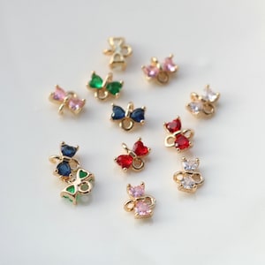 May include: Assortment of gold butterfly charms with various colored crystal accents. The charms feature a variety of colors including red, blue, green, pink, and clear.