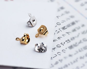 May include: Four earring findings in gold and silver tones. The findings are small and have a loop at the top for attaching earrings.