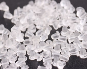 May include: A large quantity of clear plastic earring backs. The backs are small and round with a small hole in the center.