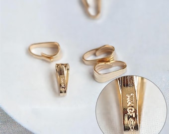 May include: Five gold-toned metal pendant clasps. The clasps are designed to hold a pendant or charm on a necklace or bracelet. The clasps are shown on a white surface. One clasp is magnified to show the inscription "14GF" on the back.