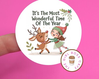 May include: A round sticker with the text "It's The Most Wonderful Time Of The Year" features a cartoon girl and reindeer dancing. A smaller circle with a coffee cup and the text "The Girl Boss Cafe" is in the bottom right corner.