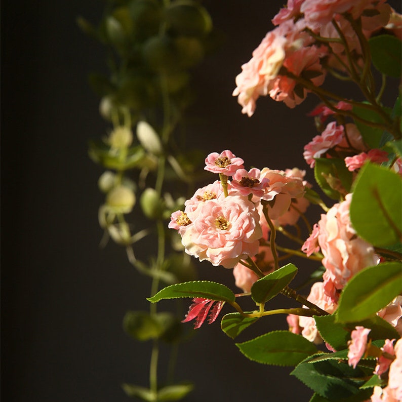 May include: A cluster of delicate pink flowers with green leaves. The flowers are in bloom and have a soft, romantic look.