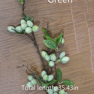 May include: Green artificial olive branch with leaves and frosted green olives. Total length: 35.43 in.