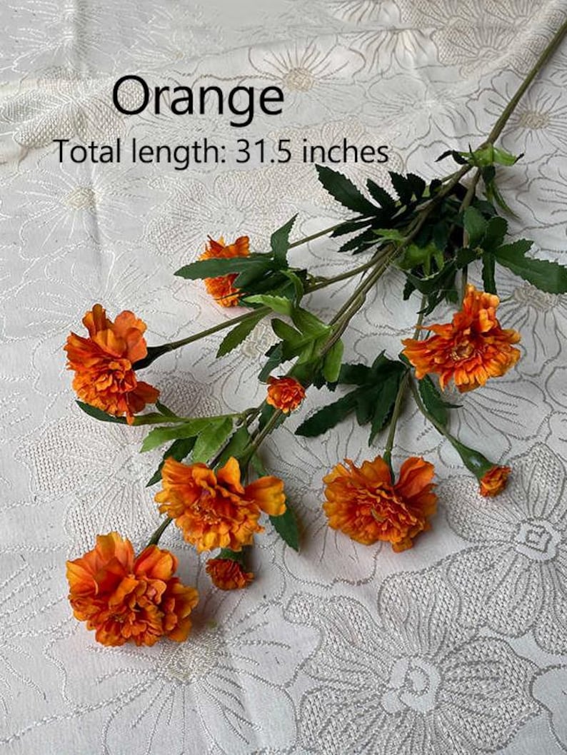 Puede incluir: Tallo de flores artificiales de color naranja con m&uacute;ltiples flores. Las flores son de color naranja intenso y tienen un aspecto arrugado. Los tallos son verdes y tienen hojas. Longitud total: 80 cm.