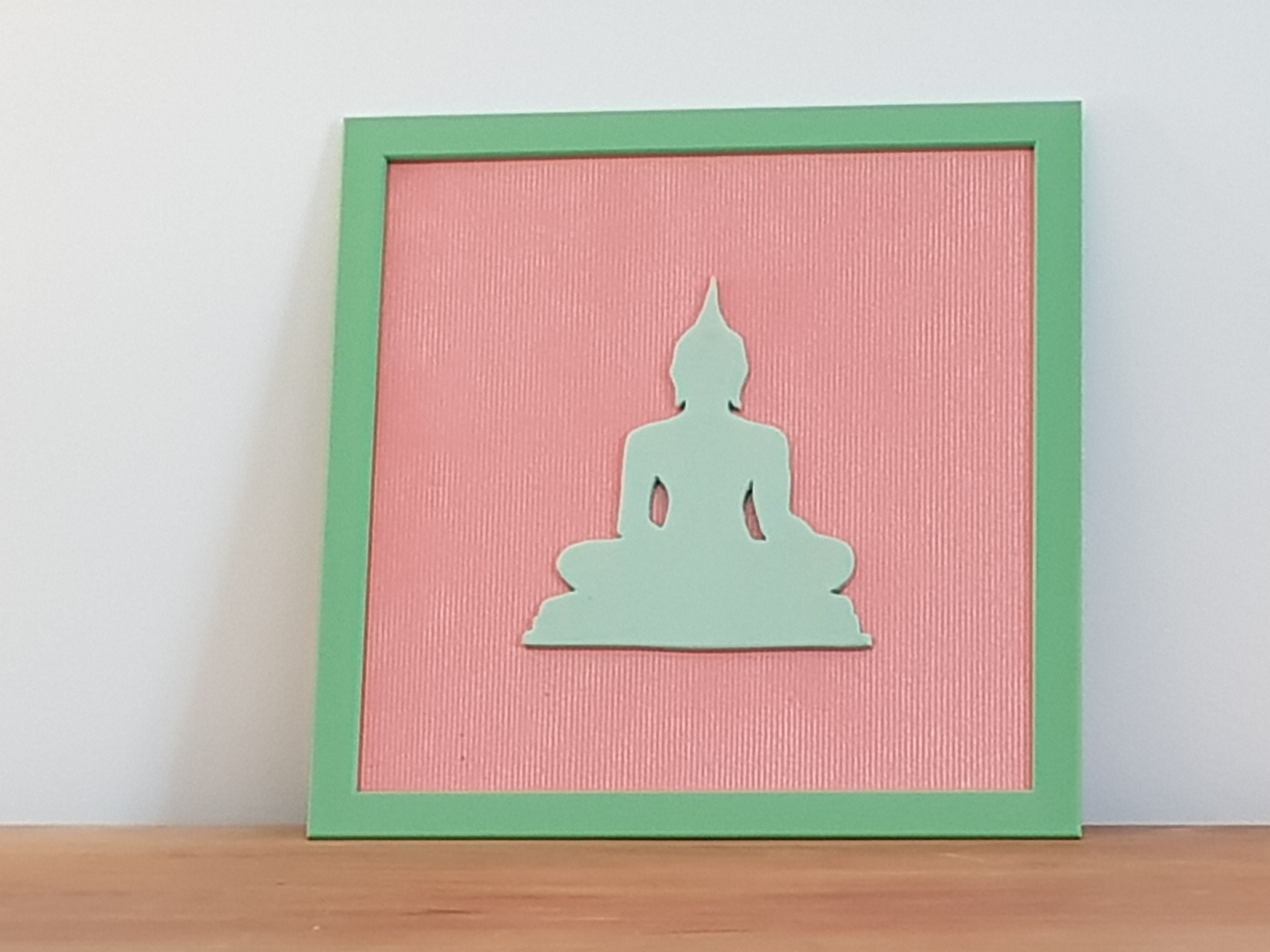 Cadre avec Bouddha de Couleur Vert Pâle sur Fond Orangé.