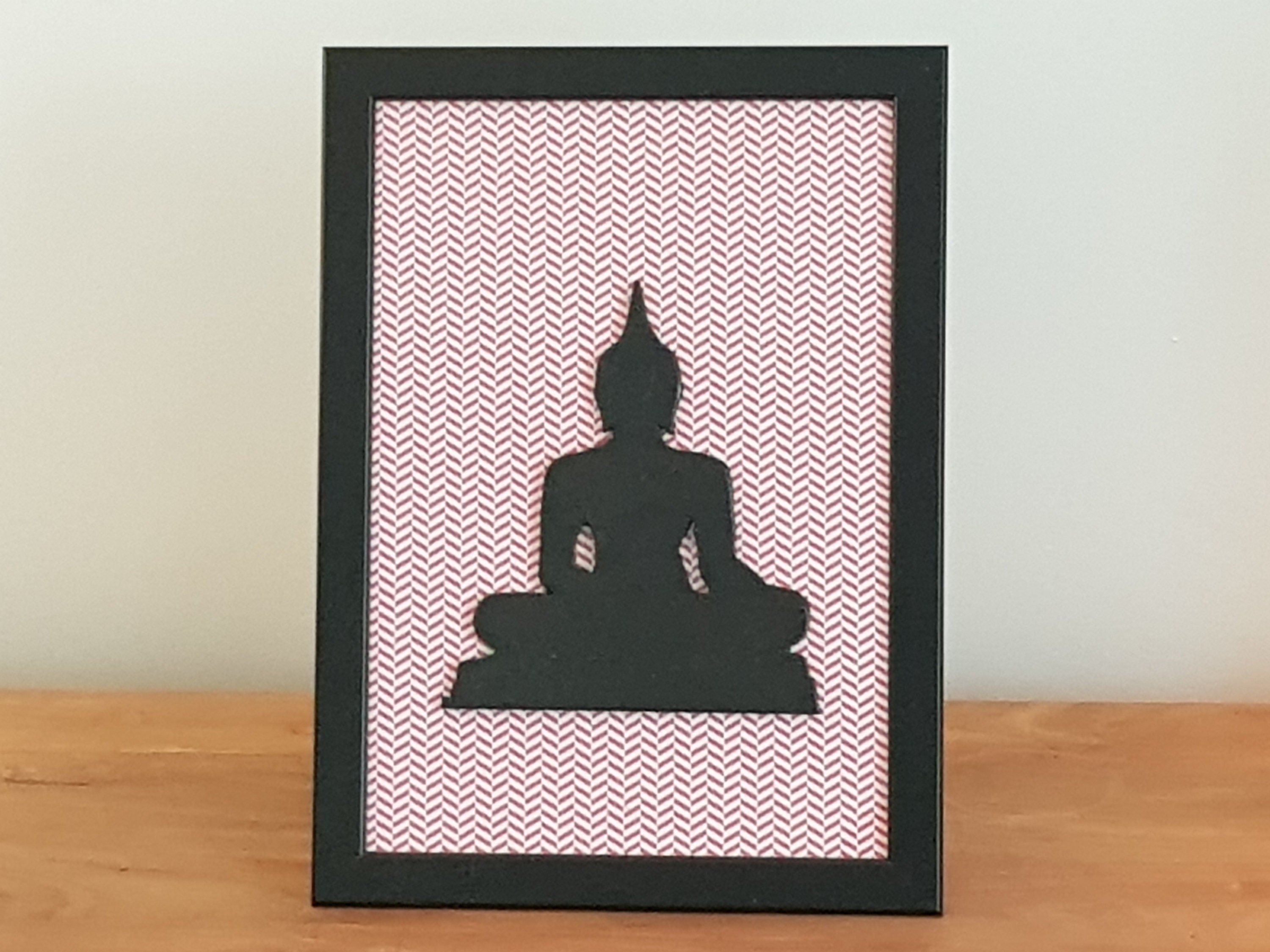 Cadre avec Bouddha Noir sur Fond Strié de Couleur Rouge
