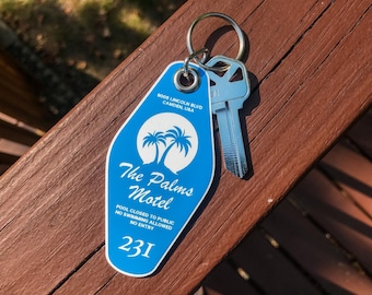 May include: A blue motel key tag with the text "The Palms Motel" and a key. The tag has a palm tree logo and the address "9008 Lincoln Blvd Camden, USA". The number "231" is printed on the tag.