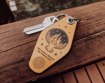 May include: A yellow key chain with a black and white owl design. The keychain features the text "The Castle Beyond The Goblin City".