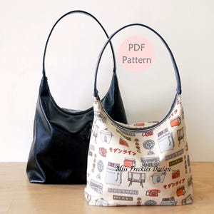 May include: Two hobo-style shoulder bags with thin dark handles. One bag is solid black, while the other features a cream-coloured fabric with a repeating pattern of vintage appliances and Japanese text. A circular label reads PDF Pattern.