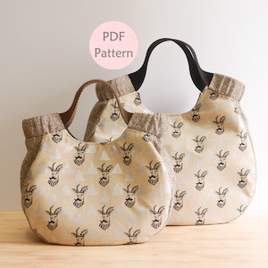 May include: Two beige tote bags with black goat head patterns. The bags have brown and black handles and a textured trim. The smaller bag is in front of the larger one. The text "PDF Pattern" is in a pink circle.