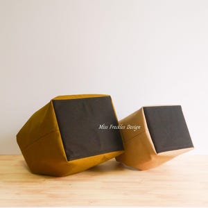 Pode incluir: Dois cestos de armazenamento em tecido com exterior amarelo mostarda e base quadrada preta. O texto Miss Freckles Design est&aacute; impresso a branco na lateral do cesto mais pequeno. Os cestos est&atilde;o inclinados para mostrar os fundos pretos.