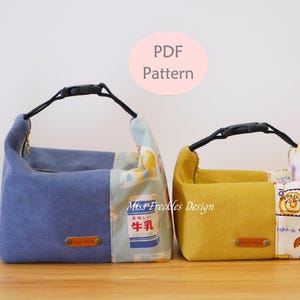 May include: Two fabric pouches with black plastic buckle handles. The larger pouch is blue with a milk carton print, and the smaller is mustard yellow with a bread print. Both feature a small brown rectangular label and the text Miss Freckles Design.