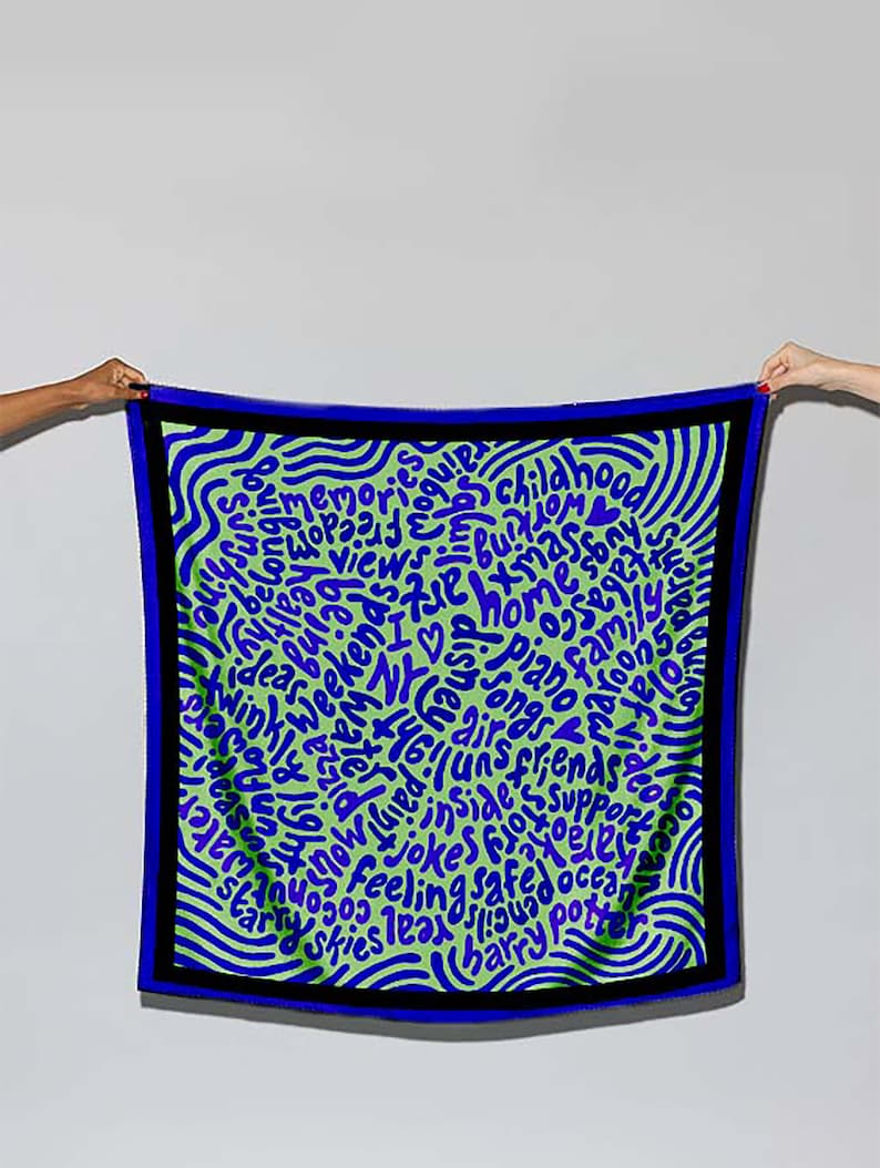 May include: A green and blue patterned silk scarf with a circular design of words in a blue and purple font. The words include "memories", "childhood", "home", "family", "songs", "friends", "jokes", "feeling safe", "ocean", "skies", "Harry Potter", and more.