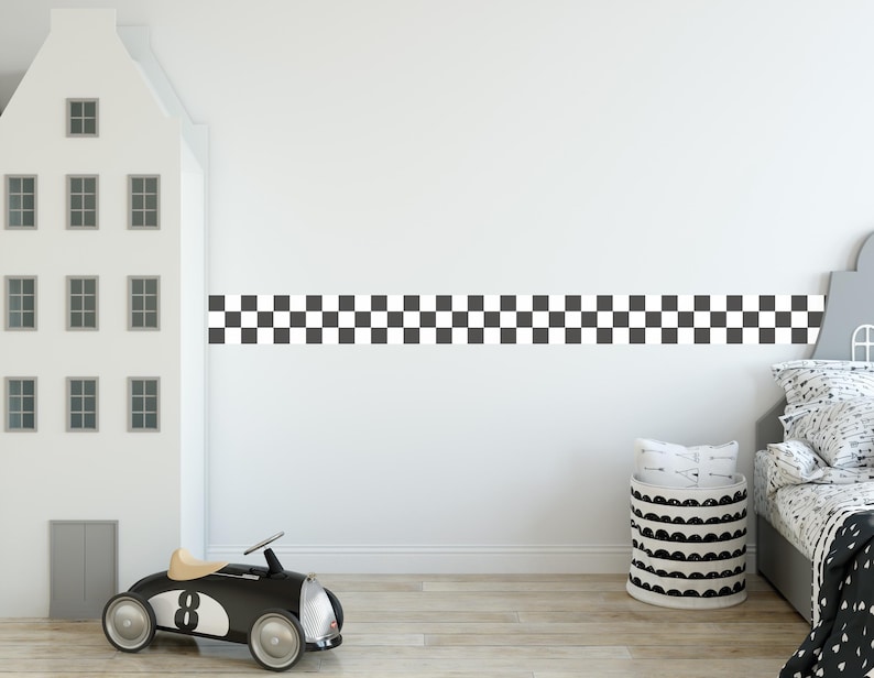 May include: A black and white checkered border runs along the wall of a room with a white toy car and a black and white storage basket.