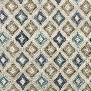 Puede incluir: Una tela beige con un patrón repetido de diamantes azules y verdes. La tela tiene un aspecto texturizado y tejido.