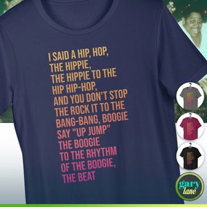 Peut inclure: T-shirt bleu marine avec l'inscription "I SAID A HIP, HOP, THE HIPPIE...THE BEAT" en orange et rose. Le t-shirt a un col rond et des manches courtes. D'autres couleurs de t-shirts sont affichées.