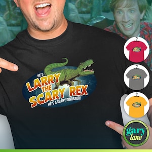Puede incluir: Camiseta negra con un dinosaurio verde y el texto "He's Larry the Scary Rex. He's a scary dinosaur!"
