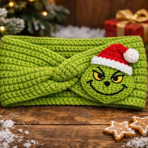 May include: A bright lime green crocheted headband featuring a twisted front design. An embroidered patch of a green character with yellow eyes and a black stitched smile wears a red and white crocheted Santa hat with a white pom-pom.