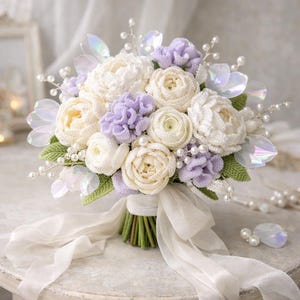 May include: A handcrafted crochet bouquet featuring white and pale yellow roses, lavender-colored flowers, and green leaves. The bouquet is adorned with faux pearls and iridescent accents, tied with a white ribbon. A beautiful floral arrangement.