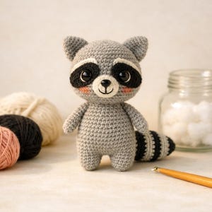 Peut inclure: Une petite poupée raton laveur crochetée à la main avec un corps gris clair, des taches oculaires noires, de grands yeux en plastique foncé, un nez brodé et des joues roses. Le raton laveur a une queue rayée et des oreilles pointues en laine.