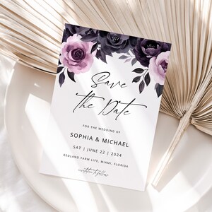May include: Save the date card with a floral design featuring purple and black flowers. The text reads "Save the Date" for the wedding of Sophia & Michael on Saturday, June 22, 2024 at Redland Farm Life, Miami, Florida.