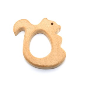 May include: A wooden squirrel-shaped teether for babies. The teether is light brown and has a smooth, rounded surface.