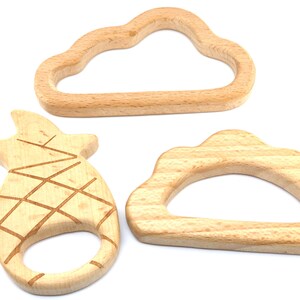 Puede incluir: Tres mordedores de madera con forma de nube, pi&ntilde;a y media luna. Los mordedores est&aacute;n hechos de madera natural y est&aacute;n dise&ntilde;ados para que los beb&eacute;s los mastiquen.