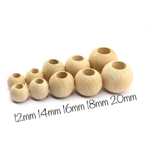 Pode incluir: Um conjunto de oito contas de madeira de diferentes tamanhos, que variam de 12 mm a 20 mm de diâmetro. As contas são todas de cor madeira natural e têm um acabamento liso e polido.