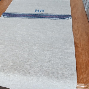 Caminho de mesa rústico feito de juta antiga com listras.