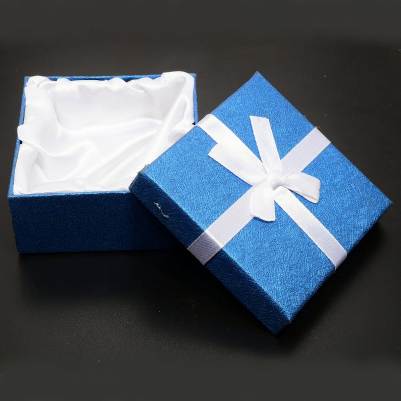 May include: A blue gift box with a white satin lining and a white ribbon tied in a bow.